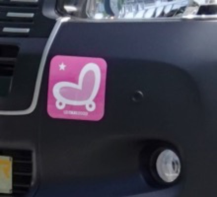 JPN TAXIの左フロントバンパーに貼られたピンクのUDステッカー