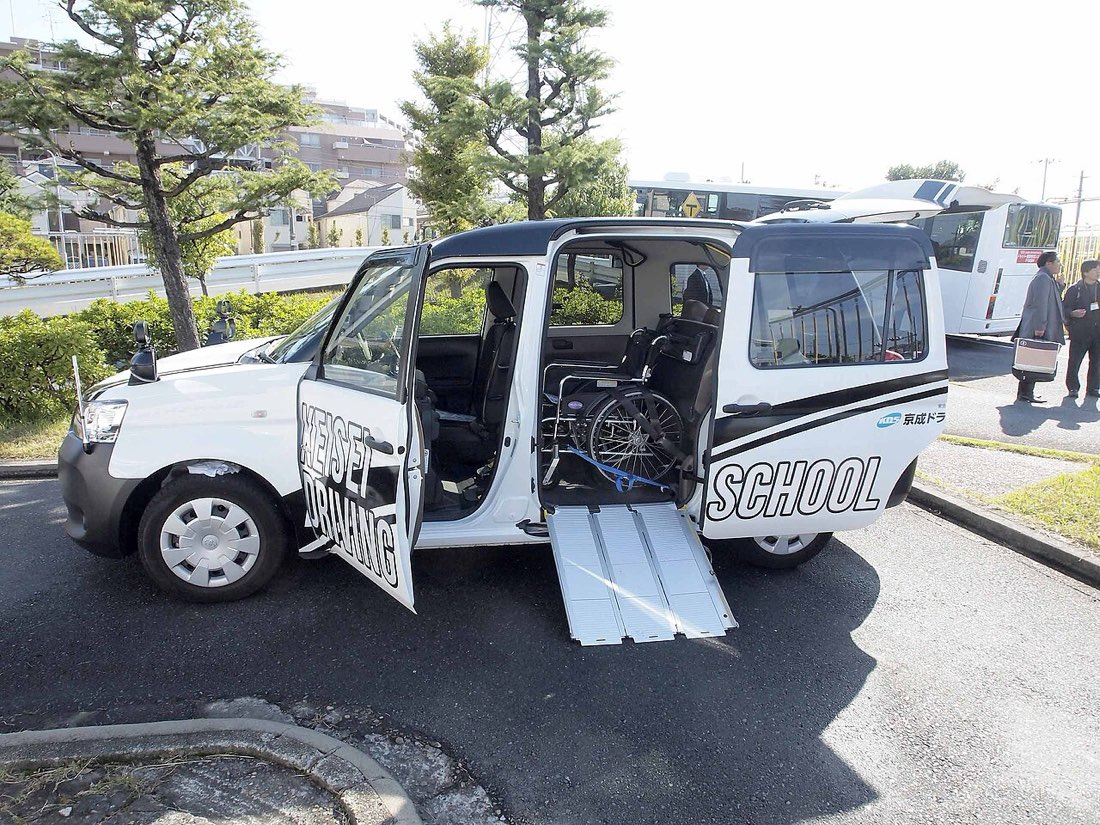 JPN TAXIのスロープを展開して車椅子を積載している様子